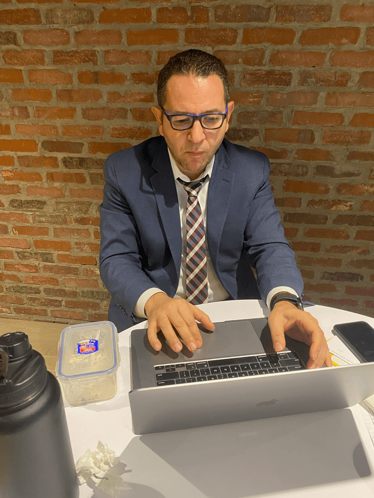 Mustafa Sualp working on a laptop in professional attire